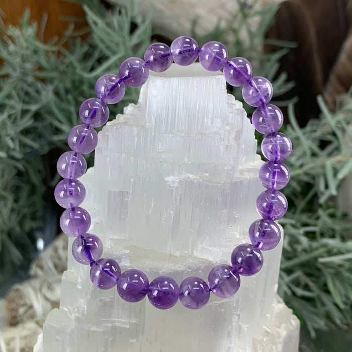 Violet amethyst bead bracelet on a selenite tower