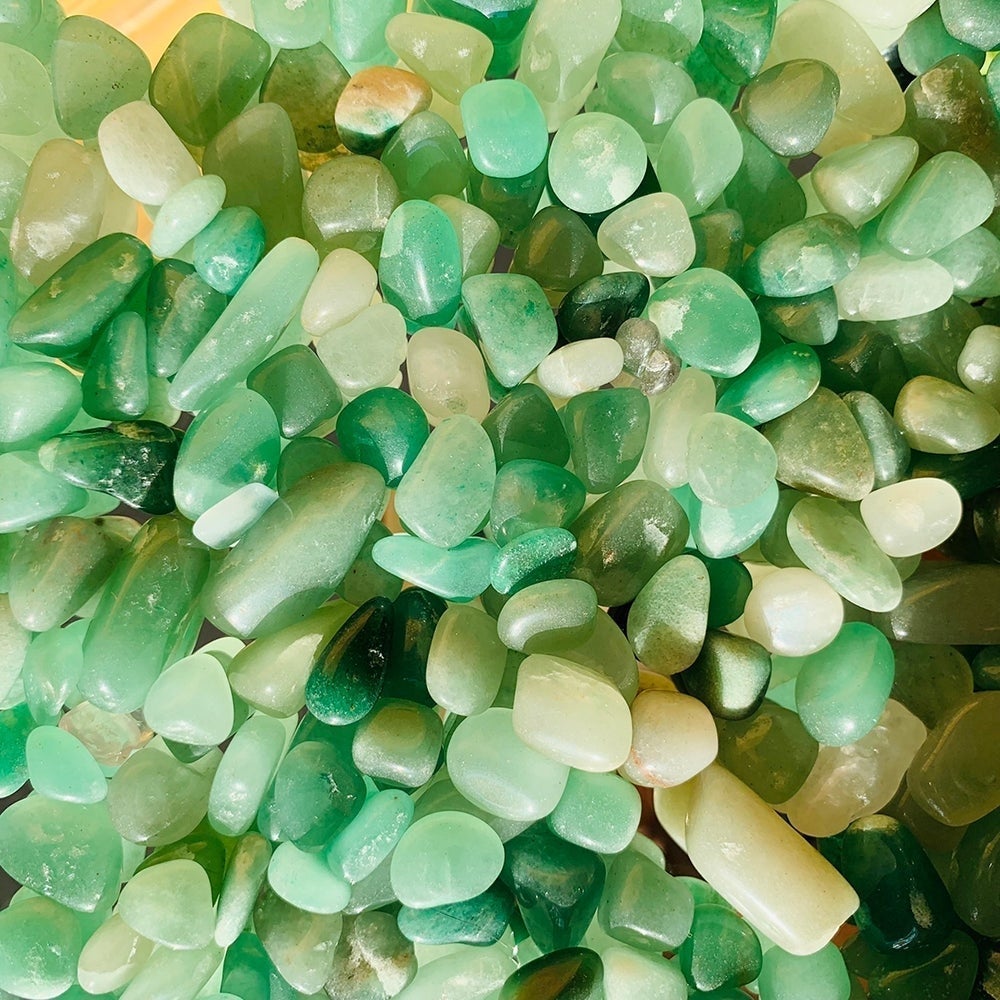 Close-up of tumbled aventurine mini gemstones in shades of mint, jade and deep green