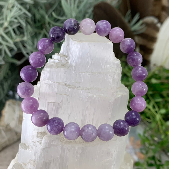 Lepidolite bead bracelet in lilac and plum on a selenite tower