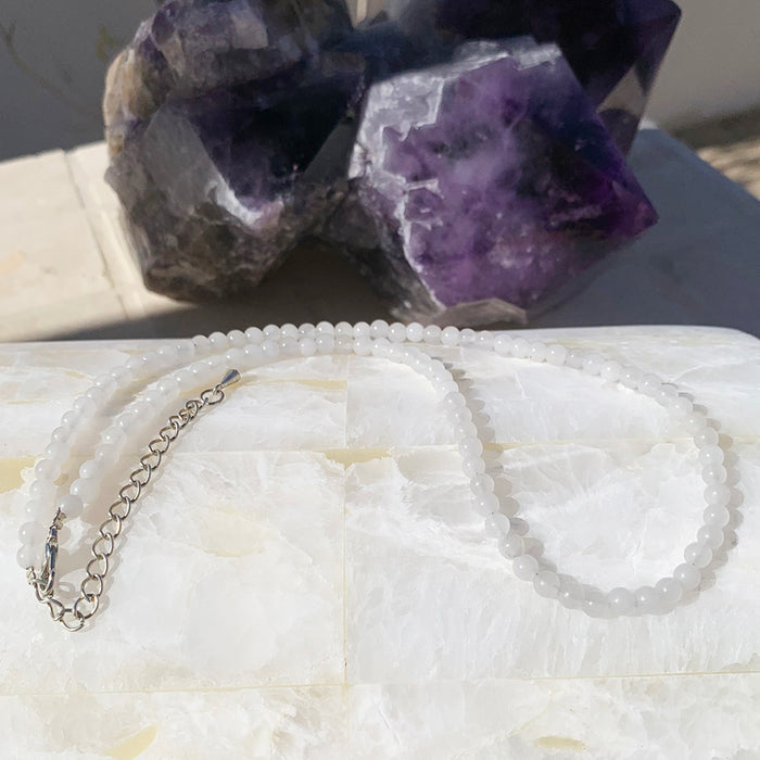 White jade beaded necklace in milky white beads on a selenite slab